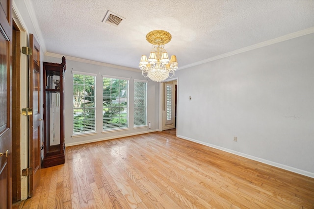 5718 Glenmere Ln, Spring, TX 77379 - spare room with a chandelier, light wood finished floors, a textured ceiling, and ornamental molding