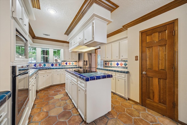 5718 Glenmere Ln, Spring, TX 77379 - kitchen with tile countertops, a textured ceiling, appliances with stainless steel finishes, backsplash, and crown molding
