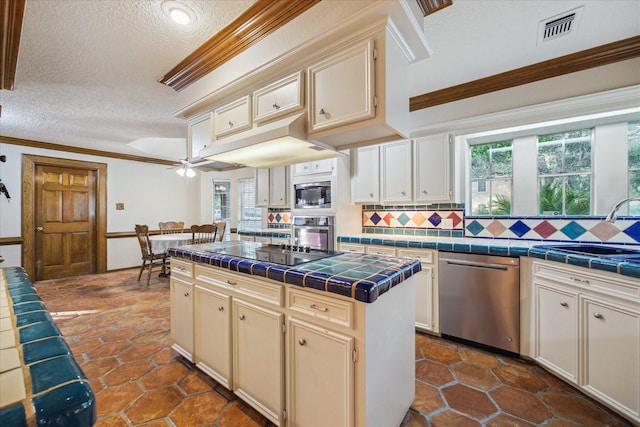 5718 Glenmere Ln, Spring, TX 77379 - kitchen featuring appliances with stainless steel finishes, tile countertops, a sink, a textured ceiling, and decorative backsplash