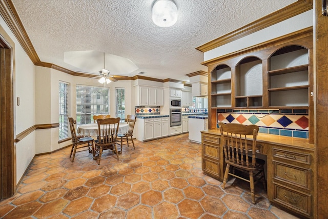 5718 Glenmere Ln, Spring, TX 77379 - dining area featuring a ceiling fan, crown molding, and a textured ceiling