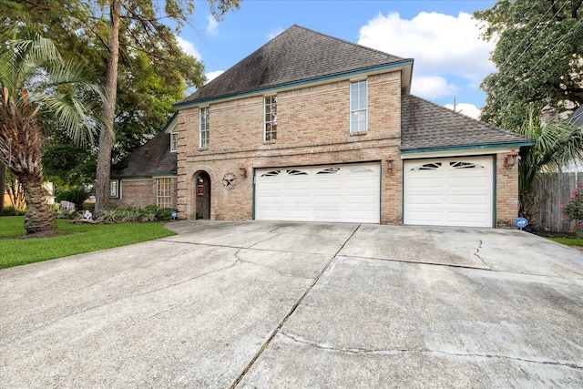 5718 Glenmere Ln, Spring, TX 77379 - view of front of house with brick siding, a shingled roof, driveway, and an attached garage