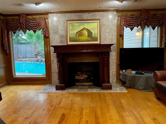 5718 Glenmere Ln, Spring, TX 77379 - detailed view of a textured ceiling, a fireplace, wood finished floors, and crown molding