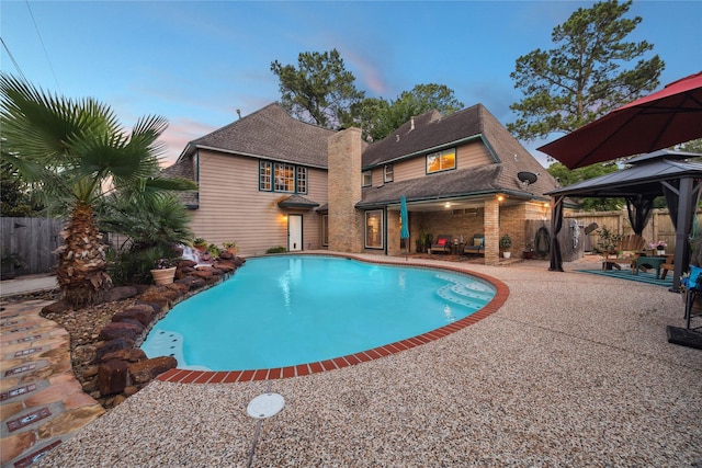 5718 Glenmere Ln, Spring, TX 77379 - pool at dusk with a gazebo and a patio area