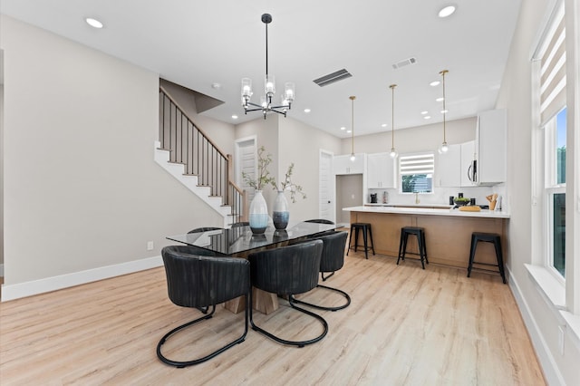 4013 Griggs Rd Unit H, Houston, TX 77021 - dining space with light wood-style floors, a chandelier, recessed lighting, baseboards, and stairway