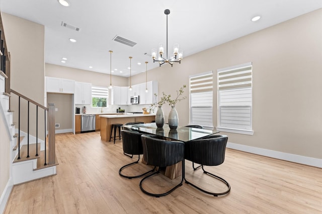 4013 Griggs Rd Unit H, Houston, TX 77021 - dining area featuring light wood-style floors, a chandelier, baseboards, stairway, and recessed lighting