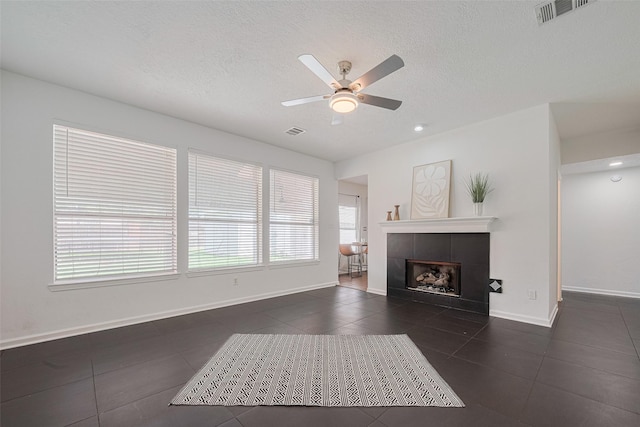 5722 Henniker Dr, Houston, TX 77041 - living area with dark tile patterned flooring, ceiling fan, a textured ceiling, baseboards, and a tile fireplace