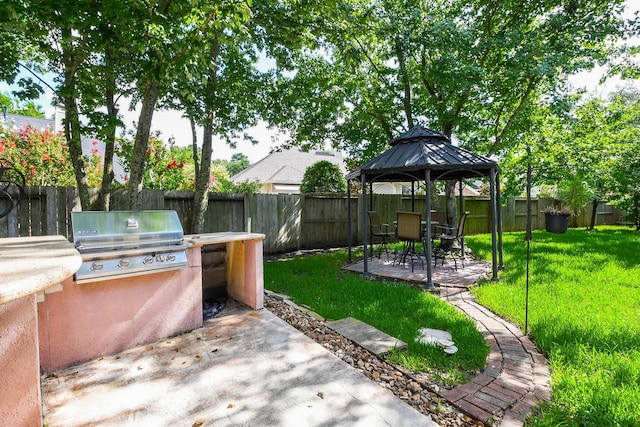 2 Camborn Pl, The Woodlands, TX 77384 - fenced backyard with a patio area, a gazebo, and an outdoor kitchen