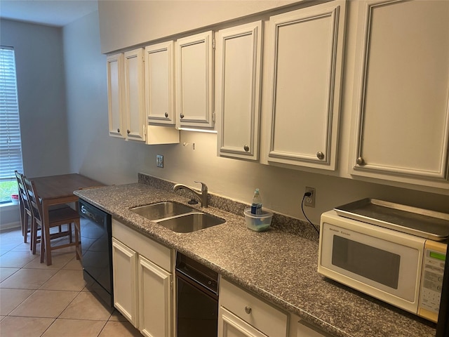 1201 Mcduffie St Unit 122, Houston, TX 77019 - kitchen with white microwave, black dishwasher, light tile patterned floors, white cabinets, and dark stone counters