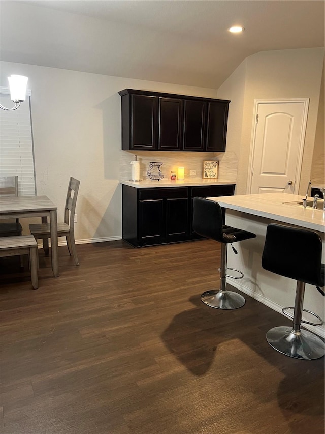 15466 Sicomoro Viejo St, Channelview, TX 77530 - kitchen featuring light countertops, a kitchen breakfast bar, dark wood-style floors, recessed lighting, and vaulted ceiling
