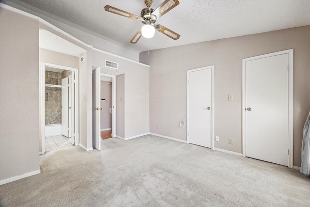 7575 Cambridge St Unit 1906, Houston, TX 77054 - unfurnished bedroom with carpet, a textured ceiling, baseboards, connected bathroom, and a ceiling fan