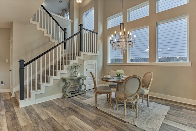 127 Kingsley Grove St, Montgomery, TX 77316 - dining space with stairway, baseboards, a towering ceiling, wood finished floors, and a chandelier