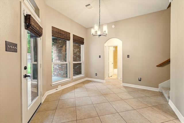 28314 Shining Creek Ln, Spring, TX 77386 - unfurnished dining area with arched walkways, light tile patterned flooring, a chandelier, and baseboards