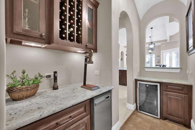 11415 W Kristina Cir, Montgomery, TX 77316 - indoor dry bar with beverage cooler, light tile patterned floors, arched walkways, decorative light fixtures, and baseboards
