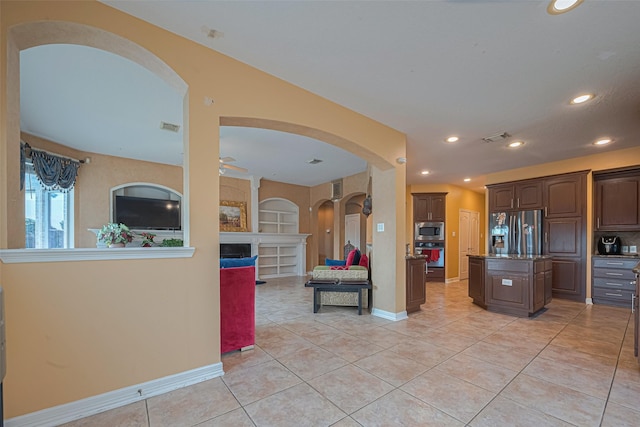 7207 Alder Springs Ct, Katy, TX 77494 - kitchen featuring appliances with stainless steel finishes, arched walkways, a ceiling fan, light tile patterned flooring, and recessed lighting