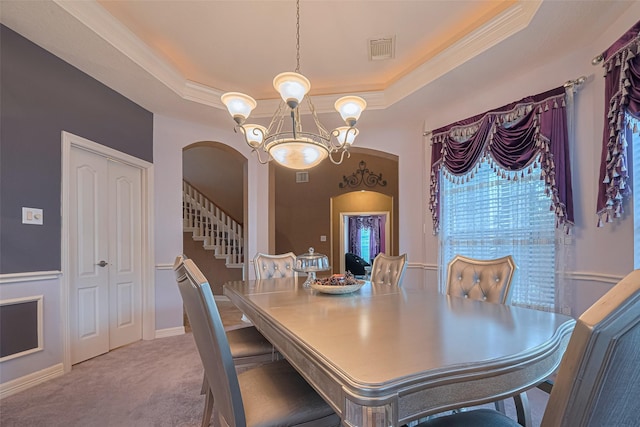 7207 Alder Springs Ct, Katy, TX 77494 - carpeted dining room with a chandelier, arched walkways, a tray ceiling, stairs, and ornamental molding