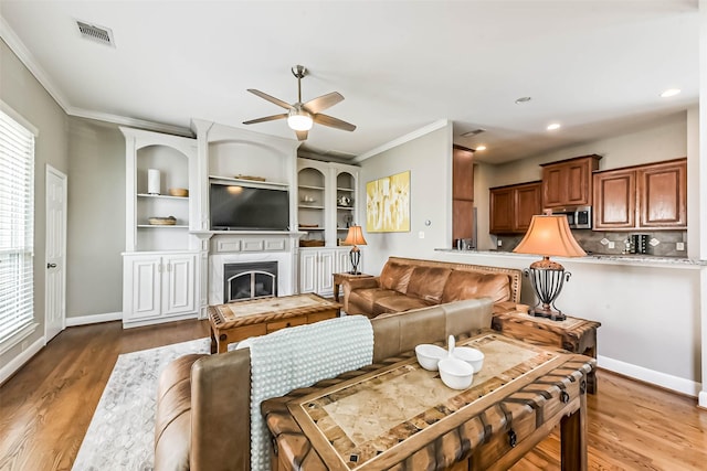 1513 Nagle St, Houston, TX 77003 - living area featuring ceiling fan, wood finished floors, ornamental molding, a fireplace, and plenty of natural light