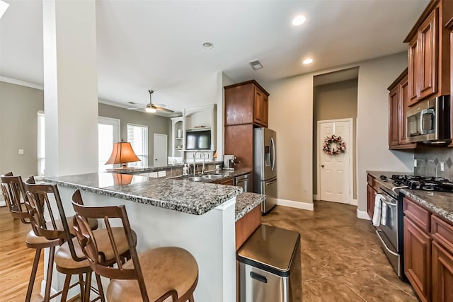 1513 Nagle St, Houston, TX 77003 - kitchen featuring appliances with stainless steel finishes, a kitchen bar, recessed lighting, dark stone countertops, and ceiling fan