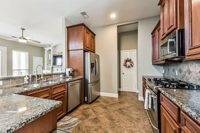 1513 Nagle St, Houston, TX 77003 - kitchen featuring stainless steel appliances, a ceiling fan, decorative backsplash, dark stone counters, and brown cabinets