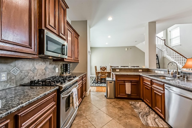 1513 Nagle St, Houston, TX 77003 - kitchen with stainless steel appliances, tasteful backsplash, dark stone counters, light tile patterned floors, and recessed lighting