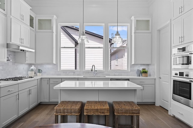 8711 Park Kolbe Ln, Houston, TX 77080 - kitchen featuring a sink, ornamental molding, gas cooktop, a breakfast bar, and stainless steel double oven