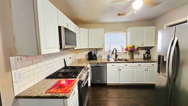 18042 Noble Forest Dr, Humble, TX 77346 - kitchen with stainless steel appliances, a sink, tasteful backsplash, dark wood finished floors, and white cabinets