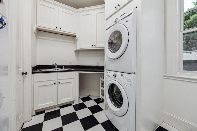 5418 Braeburn Dr, Bellaire, TX 77401 - laundry area featuring stacked washing machine and dryer, light flooring, and cabinet space