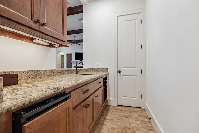 5418 Braeburn Dr, Bellaire, TX 77401 - kitchen with a sink, a ceiling fan, light stone countertops, arched walkways, and baseboards