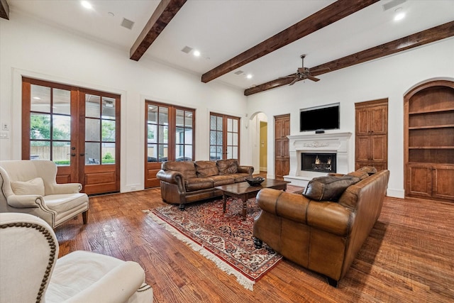 5418 Braeburn Dr, Bellaire, TX 77401 - living room with french doors, ceiling fan, wood finished floors, arched walkways, and beamed ceiling