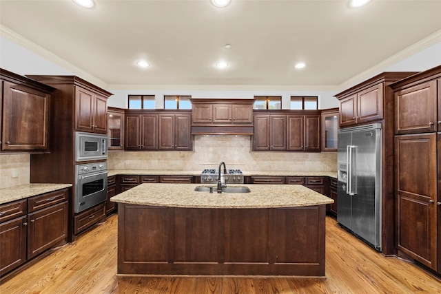 2403 Commonwealth St, Houston, TX 77006 - kitchen with appliances with stainless steel finishes, a sink, ornamental molding, a center island with sink, and dark brown cabinetry