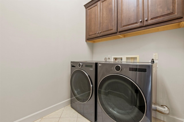 2403 Commonwealth St, Houston, TX 77006 - laundry area featuring cabinet space, baseboards, washing machine and dryer, and light tile patterned flooring
