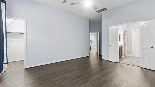 18010 Wagstaff Way, Richmond, TX 77407 - unfurnished bedroom featuring dark wood-style flooring, a spacious closet, baseboards, ensuite bath, and a ceiling fan