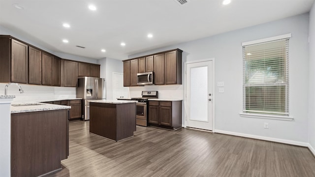 18010 Wagstaff Way, Richmond, TX 77407 - kitchen featuring appliances with stainless steel finishes, a sink, backsplash, a kitchen island, and recessed lighting