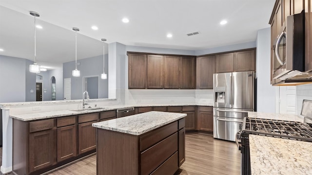 18010 Wagstaff Way, Richmond, TX 77407 - kitchen with stainless steel appliances, a sink, light wood-style floors, a peninsula, and recessed lighting