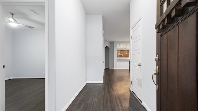 18010 Wagstaff Way, Richmond, TX 77407 - hallway featuring dark wood finished floors, baseboards, and arched walkways