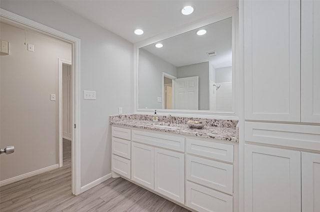 19722 Pioneer Ct, Humble, TX 77346 - bathroom featuring vanity, wood finished floors, baseboards, and recessed lighting