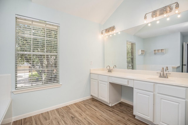 311 Vantage Pointe Cir, League City, TX 77573 - bathroom featuring double vanity, vaulted ceiling, wood finished floors, a tub, and baseboards