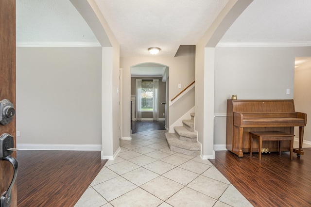 311 Vantage Pointe Cir, League City, TX 77573 - entryway featuring light wood-style flooring, arched walkways, ornamental molding, baseboards, and stairway