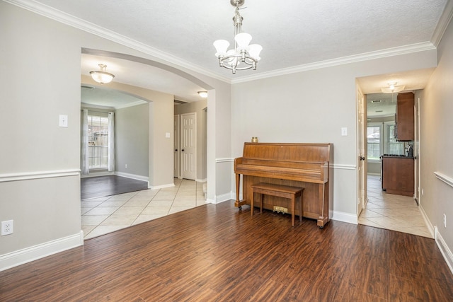 311 Vantage Pointe Cir, League City, TX 77573 - living area with arched walkways, plenty of natural light, wood finished floors, a chandelier, and crown molding