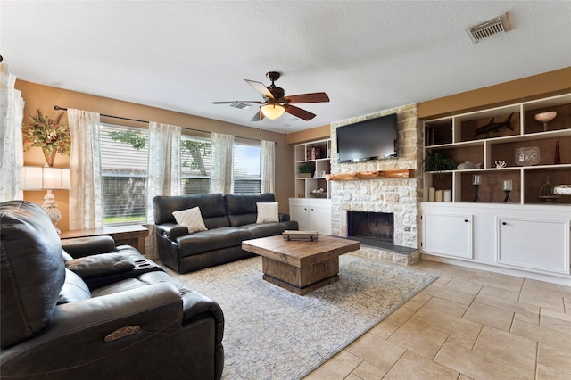 3803 Shiloh Park Ct, Friendswood, TX 77546 - living area featuring a ceiling fan, a stone fireplace, built in shelves, and a textured ceiling