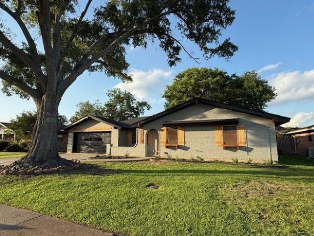 674 Meadowgreen Dr, Port Neches, TX 77651 - ranch-style house with an attached garage, a front lawn, and central air condition unit