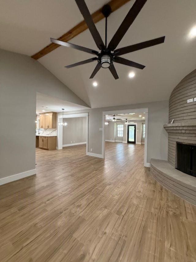 674 Meadowgreen Dr, Port Neches, TX 77651 - unfurnished living room featuring a ceiling fan, a fireplace, beamed ceiling, baseboards, and light wood-type flooring