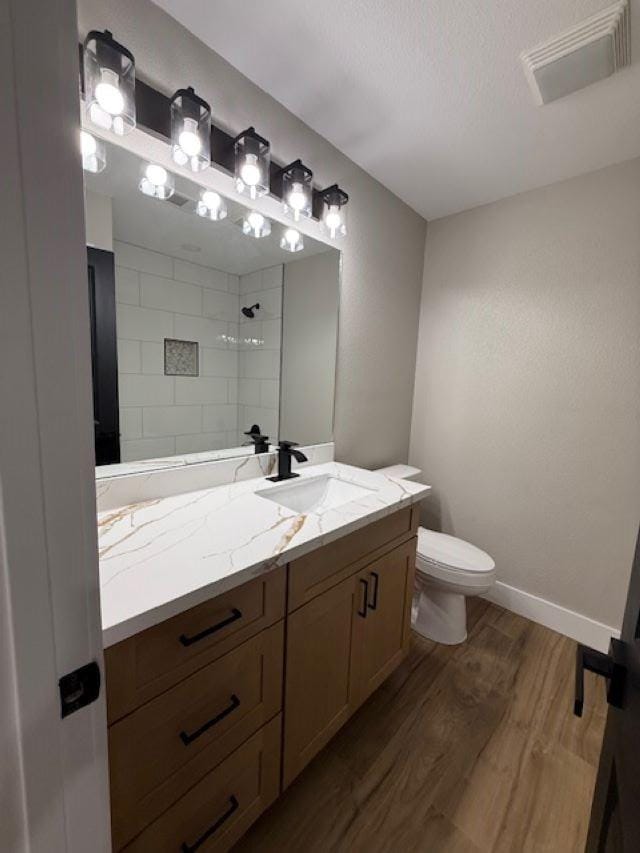 674 Meadowgreen Dr, Port Neches, TX 77651 - full bathroom featuring tiled shower, wood finished floors, toilet, vanity, and baseboards
