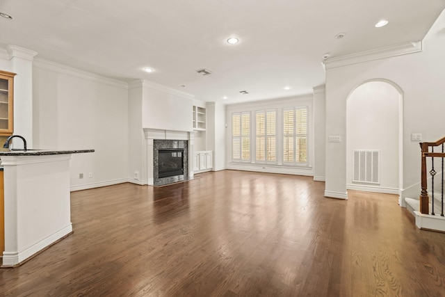 9269 Buffalo Speedway, Houston, TX 77025 - unfurnished living room with built in features, dark wood-style floors, ornamental molding, recessed lighting, and a premium fireplace