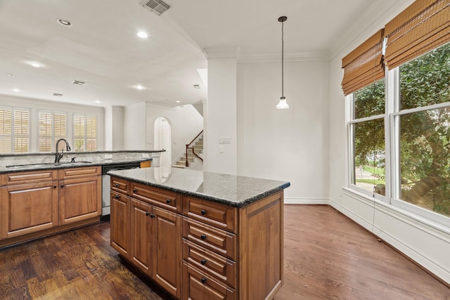 9269 Buffalo Speedway, Houston, TX 77025 - kitchen with a sink, stainless steel dishwasher, ornamental molding, a kitchen island, and dark wood-style flooring