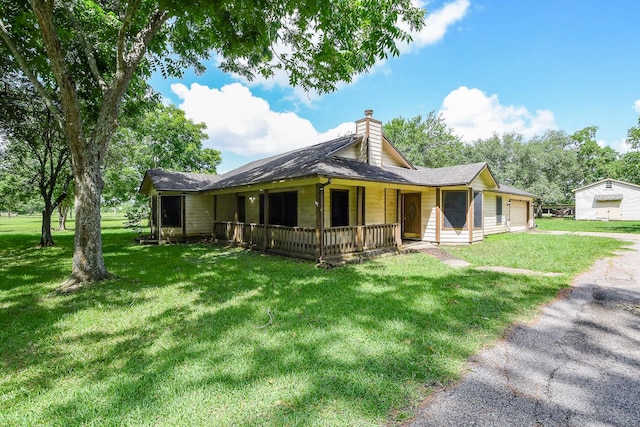 1083 County Rd 147, Alvin, TX 77511 - view of front of home featuring covered porch, a chimney, a front lawn, a garage, and driveway