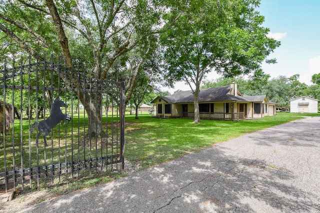 1083 County Rd 147, Alvin, TX 77511 - ranch-style home featuring covered porch, a front yard, a chimney, and a detached garage