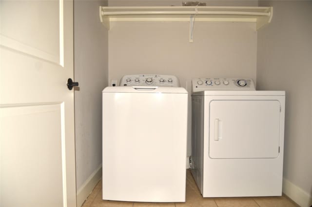 2203 Dorrington St Unit 403, Houston, TX 77030 - washroom with independent washer and dryer, light tile patterned floors, and baseboards