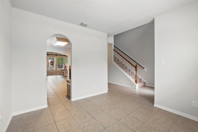 9210 E Lakeside Dr, Magnolia, TX 77354 - spare room with light tile patterned floors, arched walkways, stairway, and baseboards