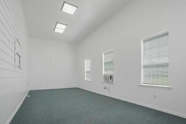 3819 Madison Ave, Baytown, TX 77523 - spare room featuring dark colored carpet, healthy amount of natural light, baseboards, cooling unit, and vaulted ceiling