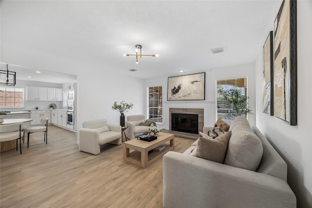 10310 Minturn Ln, Houston, TX 77064 - living room with a chandelier, light wood finished floors, a glass covered fireplace, and recessed lighting